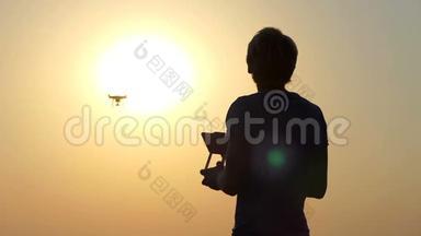 金发摄影师在太阳落山时使用一个飞行的四翼飞行器